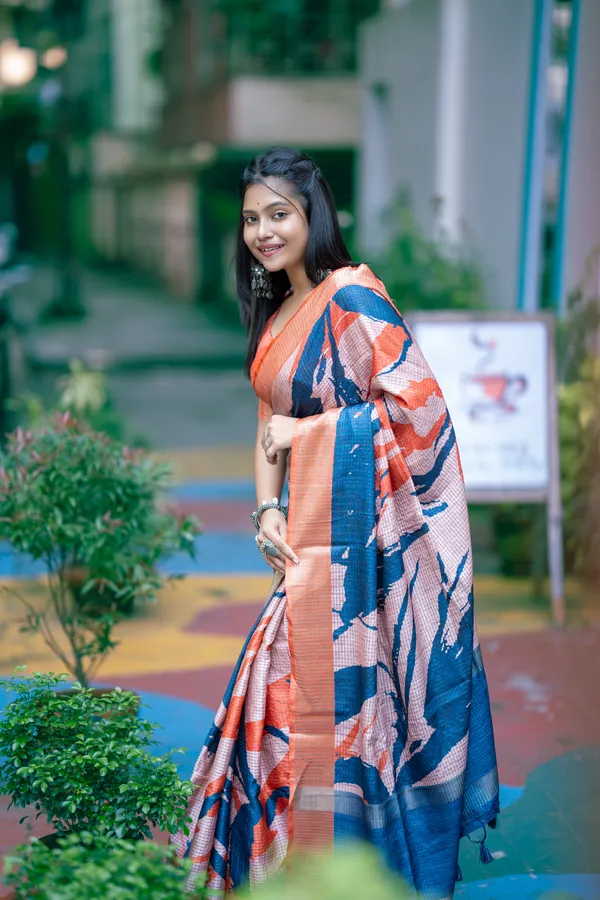 Aarathi_Blue_&_Orange_–_Aarti_Glow_Diwali_Special_|_Soft_Tussar_Silk_Saree_with_Digital_Print,_Checks_Design_Saree_&_Digital_Print_Blouse_with_Tassels