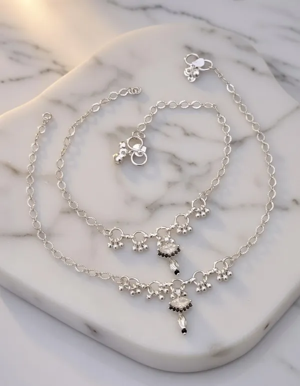 These_anklets_have_a_beautiful,_refined_look!_The_white_stone_center_with_the_black_bead_detailing_gives_them_a_very_"high-end_fusion"_feel_that_works_for_both_festive_occasions_and_everyday_elegance.__Here_is_the_SEO-optimized_content_for_Vihal_Jewellery.__Product_Title_Silver-Plated_White_Stone_&_Black_Bead_Drop_Anklets_with_Ghungroo_-_Pair_of_2_|_Vihal_Jewellery