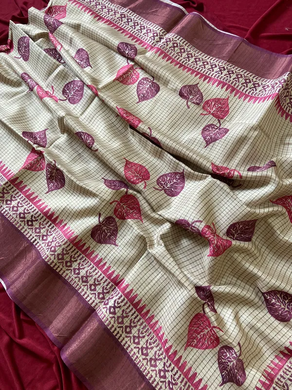 Soft_Tussar_Silk_sarees_with_Beautiful_Hand-Block_Inspired_Leaf_Digitel_Print:_The_primary_motif_consists_of_pipal_leaf_patterns_in_vibrant_shades_With_Temple_Border_The_serrated,_triangular_pattern_lining_the_is_a_classic_Indian_design_known_as_a_Temple_border_or_Temple_motif._This_is_a_staple_in_traditional_South_Indian_textiles_With_Attractive_Checks_Design_Saree_And_Digital_Print_Blouse_With_Tassels