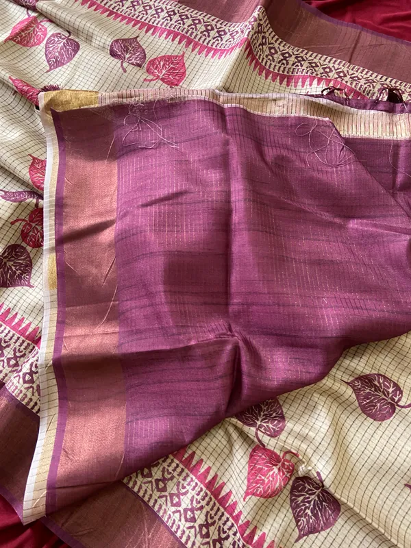 Soft_Tussar_Silk_sarees_with_Beautiful_Hand-Block_Inspired_Leaf_Digitel_Print:_The_primary_motif_consists_of_pipal_leaf_patterns_in_vibrant_shades_With_Temple_Border_The_serrated,_triangular_pattern_lining_the_is_a_classic_Indian_design_known_as_a_Temple_border_or_Temple_motif._This_is_a_staple_in_traditional_South_Indian_textiles_With_Attractive_Checks_Design_Saree_And_Digital_Print_Blouse_With_Tassels