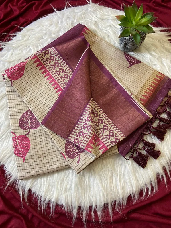 Soft_Tussar_Silk_sarees_with_Beautiful_Hand-Block_Inspired_Leaf_Digitel_Print:_The_primary_motif_consists_of_pipal_leaf_patterns_in_vibrant_shades_With_Temple_Border_The_serrated,_triangular_pattern_lining_the_is_a_classic_Indian_design_known_as_a_Temple_border_or_Temple_motif._This_is_a_staple_in_traditional_South_Indian_textiles_With_Attractive_Checks_Design_Saree_And_Digital_Print_Blouse_With_Tassels