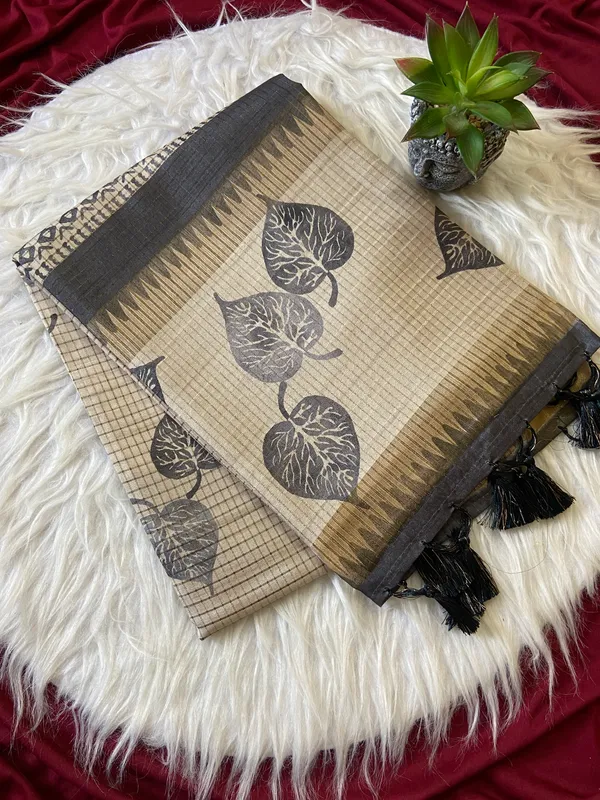 Soft_Tussar_Silk_sarees_with_Beautiful_Hand-Block_Inspired_Leaf_Digitel_Print:_The_primary_motif_consists_of_pipal_leaf_patterns_in_vibrant_shades_With_Temple_Border_The_serrated,_triangular_pattern_lining_the_is_a_classic_Indian_design_known_as_a_Temple_border_or_Temple_motif._This_is_a_staple_in_traditional_South_Indian_textiles_With_Attractive_Checks_Design_Saree_And_Digital_Print_Blouse_With_Tassels
