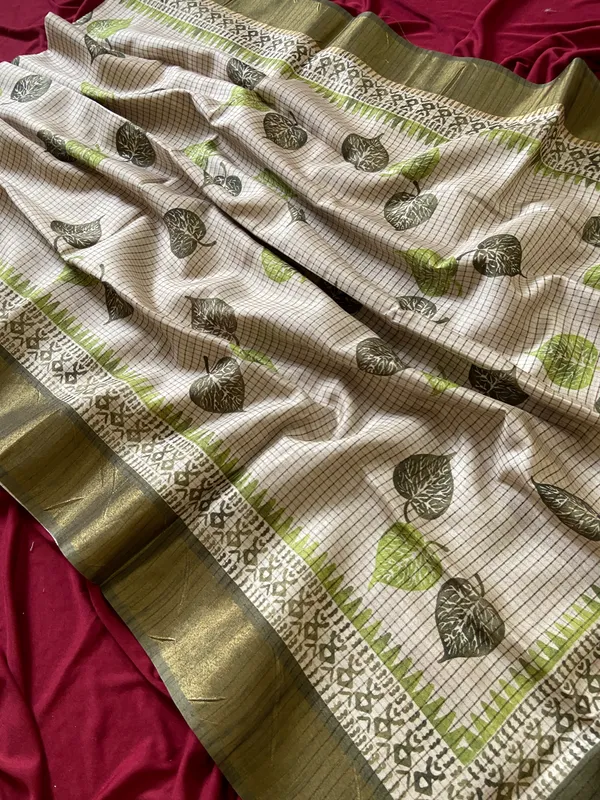 Soft_Tussar_Silk_sarees_with_Beautiful_Hand-Block_Inspired_Leaf_Digitel_Print:_The_primary_motif_consists_of_pipal_leaf_patterns_in_vibrant_shades_With_Temple_Border_The_serrated,_triangular_pattern_lining_the_is_a_classic_Indian_design_known_as_a_Temple_border_or_Temple_motif._This_is_a_staple_in_traditional_South_Indian_textiles_With_Attractive_Checks_Design_Saree_And_Digital_Print_Blouse_With_Tassels