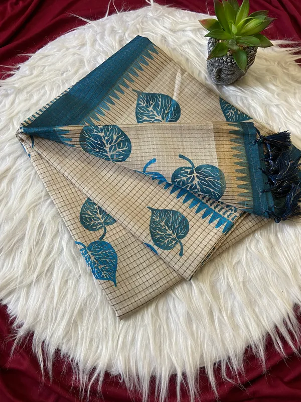 Soft_Tussar_Silk_sarees_with_Beautiful_Hand-Block_Inspired_Leaf_Digitel_Print:_The_primary_motif_consists_of_pipal_leaf_patterns_in_vibrant_shades_With_Temple_Border_The_serrated,_triangular_pattern_lining_the_is_a_classic_Indian_design_known_as_a_Temple_border_or_Temple_motif._This_is_a_staple_in_traditional_South_Indian_textiles_With_Attractive_Checks_Design_Saree_And_Digital_Print_Blouse_With_Tassels