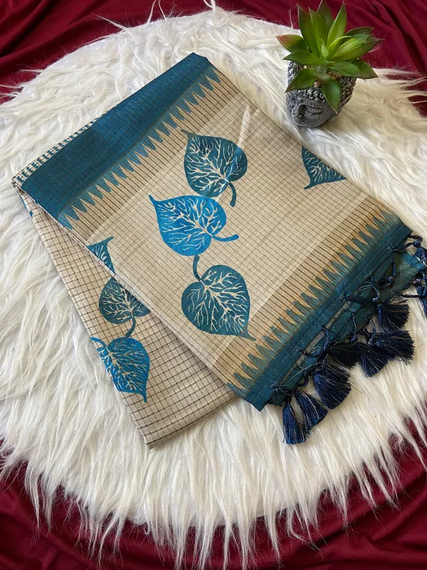 Soft_Tussar_Silk_sarees_with_Beautiful_Hand-Block_Inspired_Leaf_Digitel_Print:_The_primary_motif_consists_of_pipal_leaf_patterns_in_vibrant_shades_With_Temple_Border_The_serrated,_triangular_pattern_lining_the_is_a_classic_Indian_design_known_as_a_Temple_border_or_Temple_motif._This_is_a_staple_in_traditional_South_Indian_textiles_With_Attractive_Checks_Design_Saree_And_Digital_Print_Blouse_With_Tassels