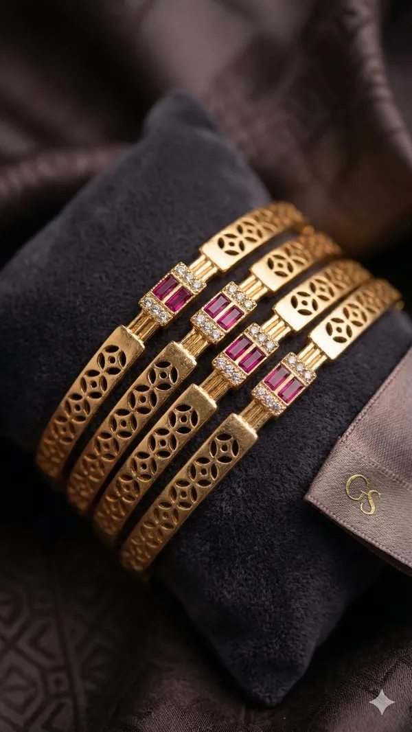 Add_A_Touch_Of_Royal_Elegance_To_Your_Jewelry_Collection_with_These_Beautifully_Crafted_Micro_Gold_Plated_And_&_Ruby_Stone_Studded_Bangles._Designed_with_Intricate_Floral_Cutwork_Detailing,_These_Bangles_Feature_A_Stunning_Centerpiece_Adorned_with_Sparkling_American_Diamonds_And_Rich_Ruby-Colored_Stones_That_Enhance_Their_Luxurious_Appeal.