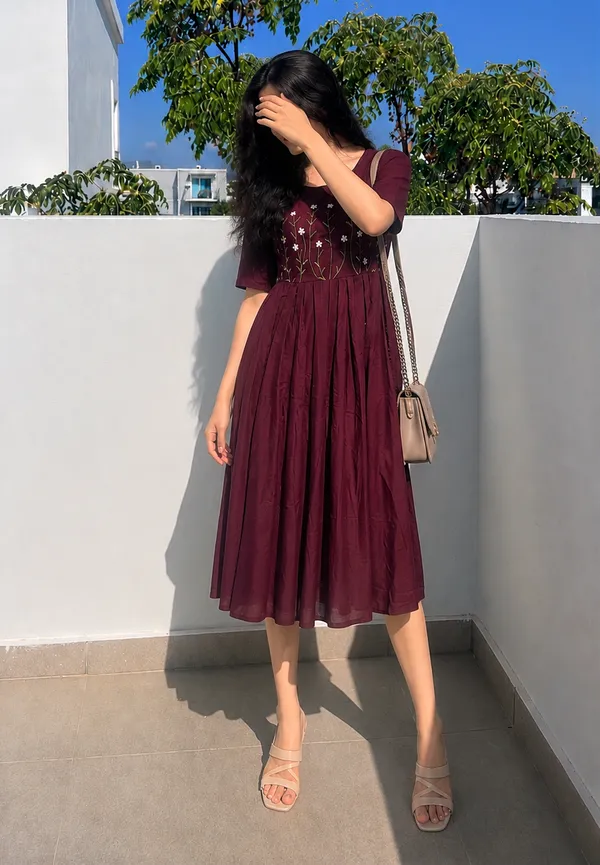 This_is_a_purple_knee-length_A-line_dress_with_short_sleeves_and_a_round_neckline._The_bodice_features_colorful_floral_embroidery._It_is_paired_with_a_beige_shoulder_bag_and_beige_sandals._This_style_is_suitable_for_casual_outings,_brunches,_or_daytime_events.