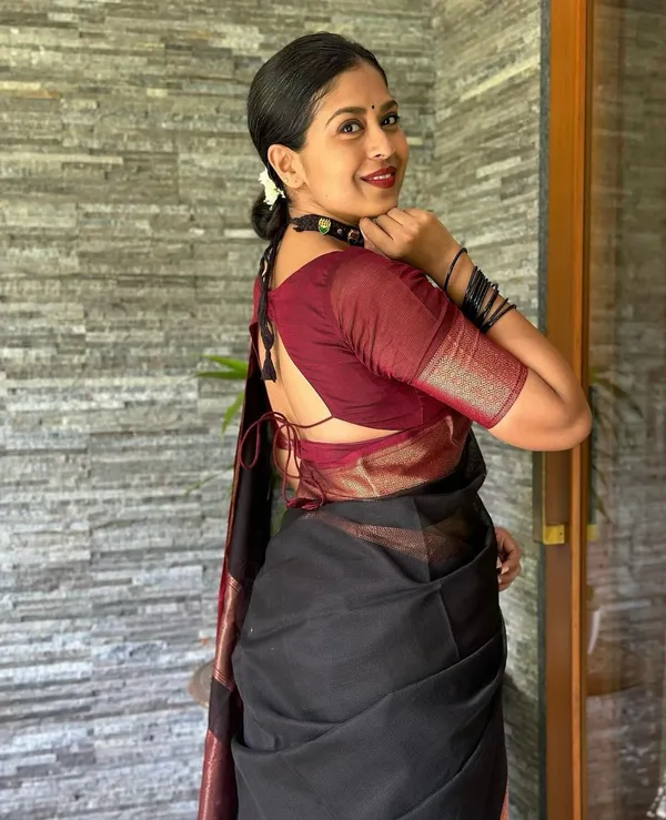 Elegant_Black_and_Maroon_Saree_with_Intricate_Gold_Patterns_and_Designer_Blouse