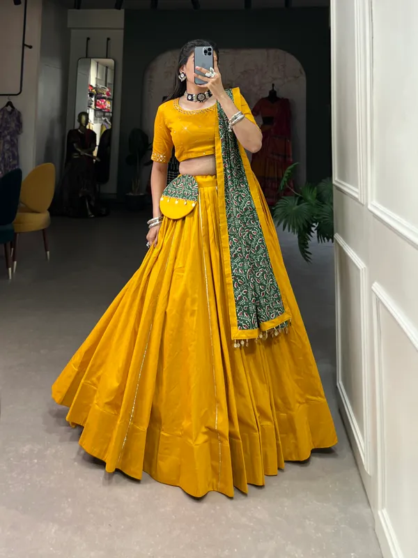 Dance_through_Navratri_nights_in_this_beautifully_printed_pure_cotton_lehenga_choli._Complete_with_a_matching_purse_and_intricate_coin_lace_detailing,_it's_perfect_for_the_celebrations