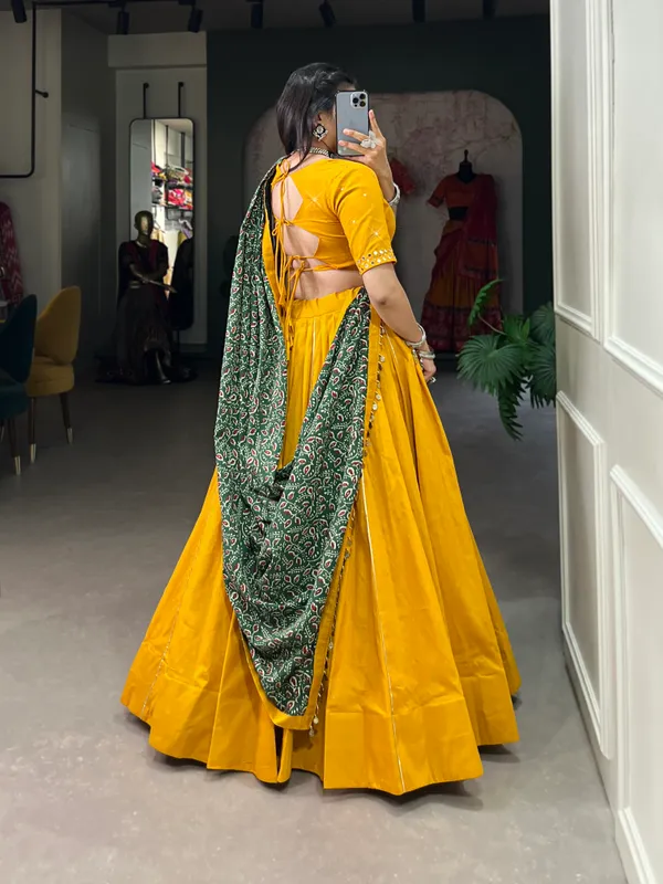 Dance_through_Navratri_nights_in_this_beautifully_printed_pure_cotton_lehenga_choli._Complete_with_a_matching_purse_and_intricate_coin_lace_detailing,_it's_perfect_for_the_celebrations