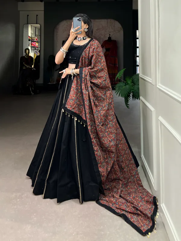 Dance_through_Navratri_nights_in_this_beautifully_printed_pure_cotton_lehenga_choli._Complete_with_a_matching_purse_and_intricate_coin_lace_detailing,_it's_perfect_for_the_celebrations