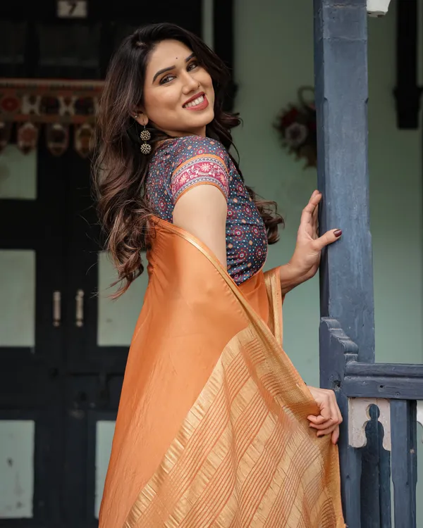 Elegant_Tangerine_Orange_Plain_Chiffon_Saree_with_Gold_Zari_Border,_Geometric_Printed_Blouse_&_Tassel_Detailing