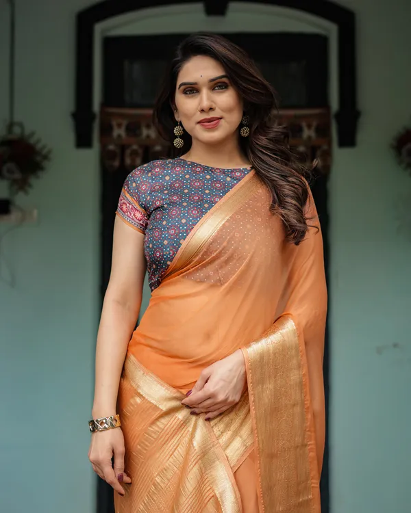 Elegant_Tangerine_Orange_Plain_Chiffon_Saree_with_Gold_Zari_Border,_Geometric_Printed_Blouse_&_Tassel_Detailing