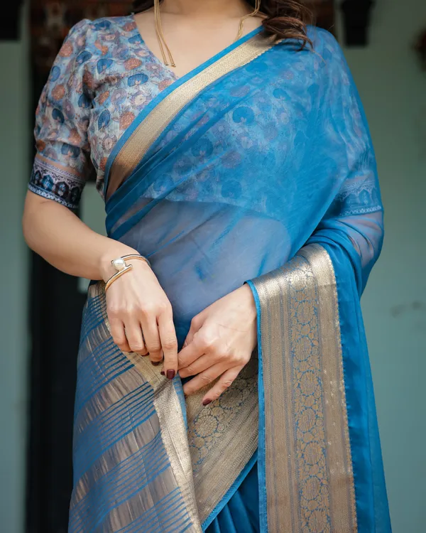 Vibrant_Peacock_Blue_Plain_Chiffon_Saree_with_Gold_Zari_Border,_Floral_Printed_Blouse_&_Tassel_Accents
