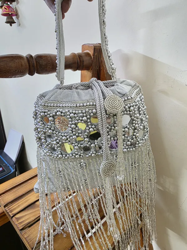 Silver_Elegant_Potli_With_Pearls,_Mirrors,_And_Fringe_Detailing