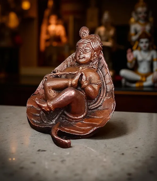 Brownish-Orange_Copper_Idols,_6_Cm,_Handmade_Bal_Krishna_Lying_In_Banyan_Leaf_82_Gram,_Patina_Antique_Finish,_Pack_Of_1_Piece