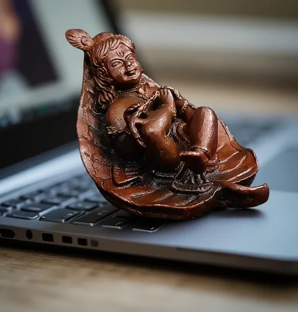 Brownish-Orange_Copper_Idols,_6_Cm,_Handmade_Bal_Krishna_Lying_In_Banyan_Leaf_82_Gram,_Patina_Antique_Finish,_Pack_Of_1_Piece
