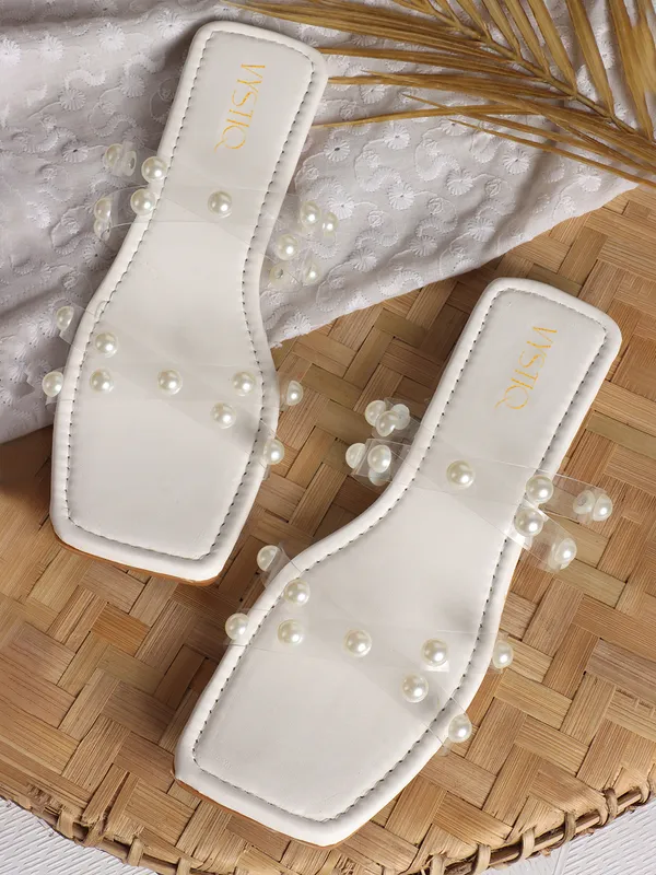 Elegant_slip-on_sandals_with_pearl-studded_,_soft_padded_insole,_and_large_decorative_front.