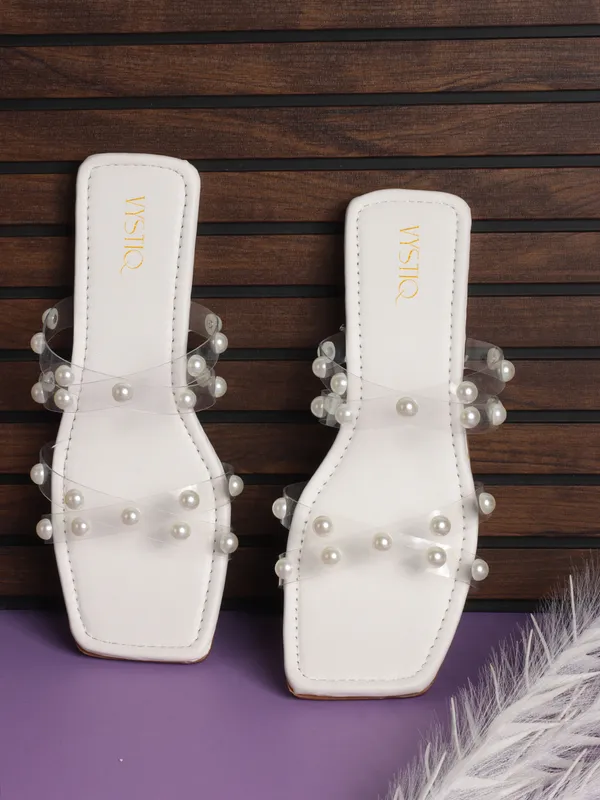 Elegant_slip-on_sandals_with_pearl-studded_,_soft_padded_insole,_and_large_decorative_front.