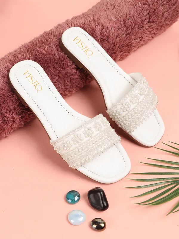 Elegant_slip-on_sandals_with_pearl-studded,_soft_padded_insole,_and_large_decorative_front.