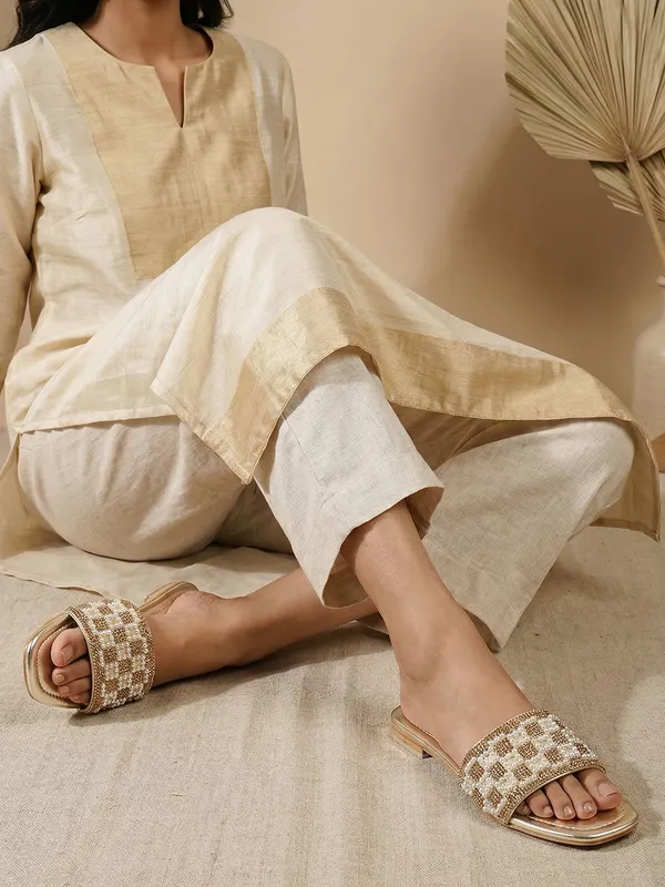These_flat_slide_sandals_feature_a_metallic_bronze_finish_on_the_footbed_and_sole