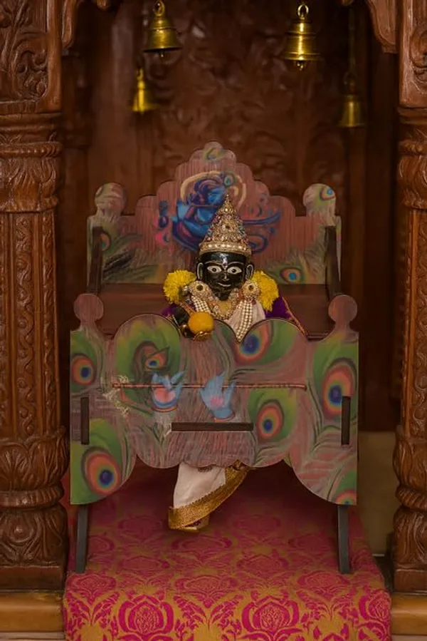 Brown_Wooden_Laddu_Gopal_Palna_Bed_With_Krishna_Bansuri_Design_&_Peacock_Feather_Print_–_Decorative_Jhula_For_Janmashtami_&_Mandir_Decor