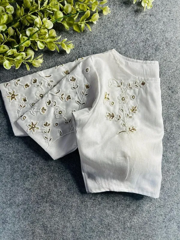 Premium_white_blouse_with_intricate_hand_embroidery_and_bead_detailing.
