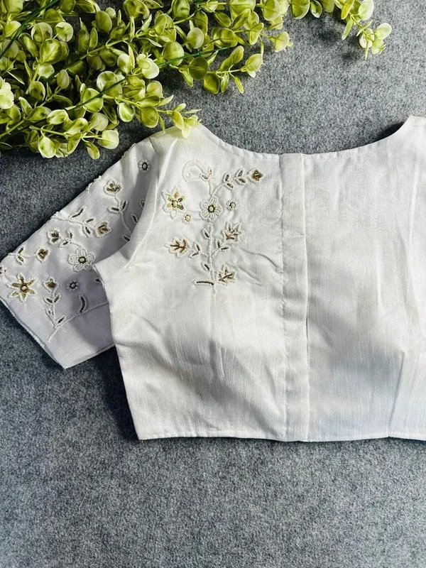 Premium_white_blouse_with_intricate_hand_embroidery_and_bead_detailing.