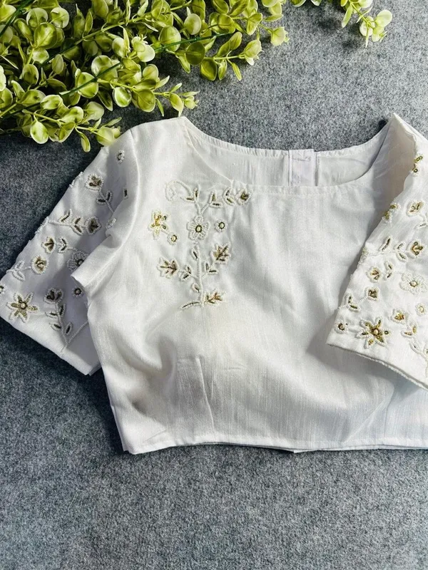 Premium_white_blouse_with_intricate_hand_embroidery_and_bead_detailing.