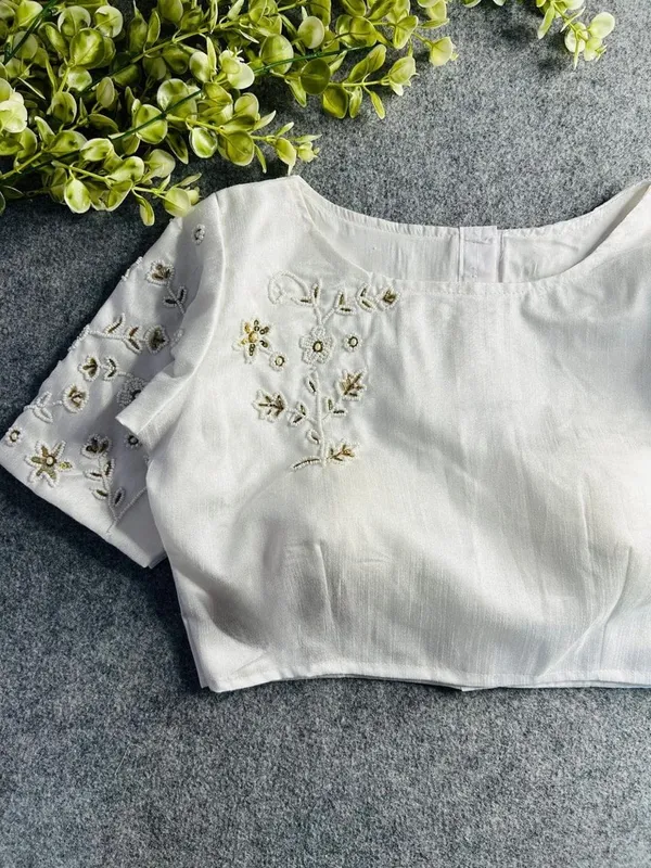 Premium_white_blouse_with_intricate_hand_embroidery_and_bead_detailing.
