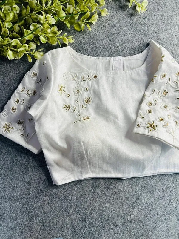 Premium_white_blouse_with_intricate_hand_embroidery_and_bead_detailing.