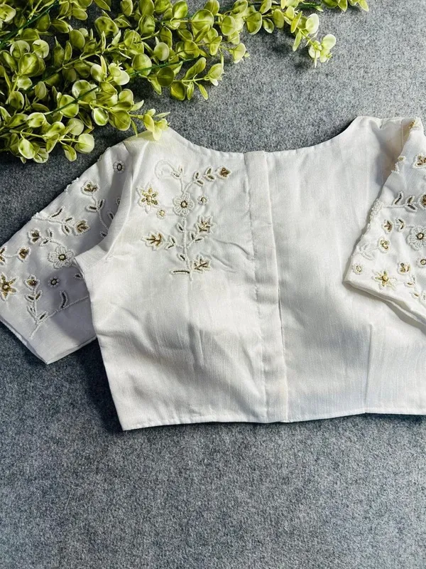 Premium_white_blouse_with_intricate_hand_embroidery_and_bead_detailing.