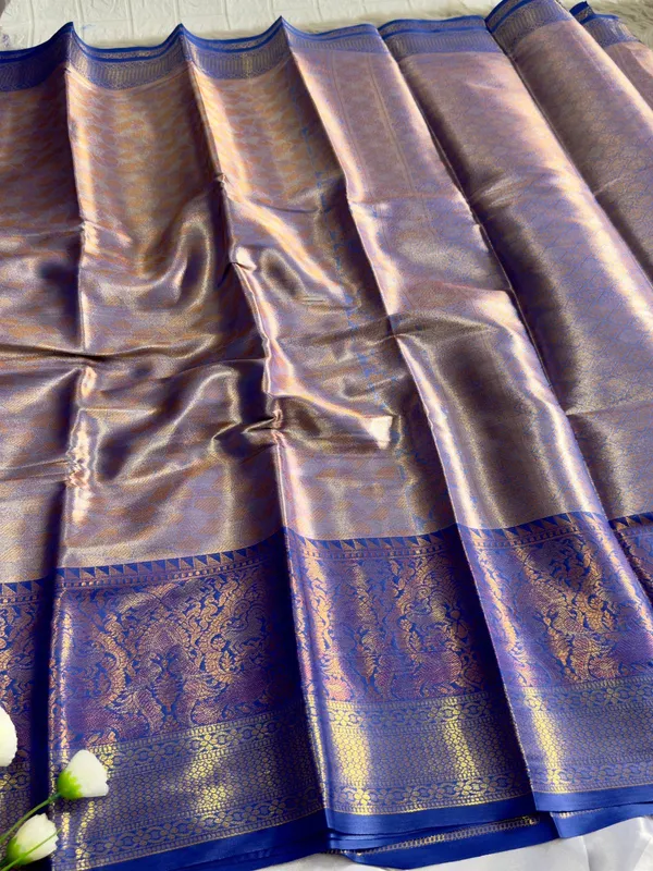 Premium_Pattu_Tissue_Silk_Saree_crafted_with_a_rich_shimmering_finish_and_elegant_woven_texture,_designed_for_graceful_festive_and_wedding_wear._The_saree_features_a_luxurious_soft_drape_with_intricate_detailing_that_enhances_its_royal_appeal._Paired_with_a_matching_blouse_piece_for_a_complete_traditional_look.
