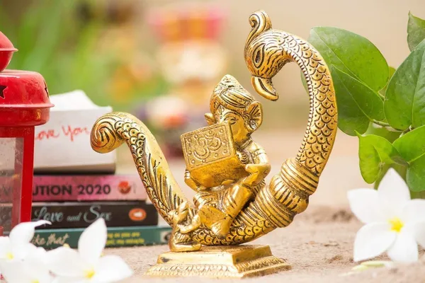 Reading_Ganesha_Idol_on_Peacock_Brass_Finish_Ganpati_Statue_with_Book_and_Om_Symbol_for_Home_Decor,_Office_Desk_&_Gift_6_Inch