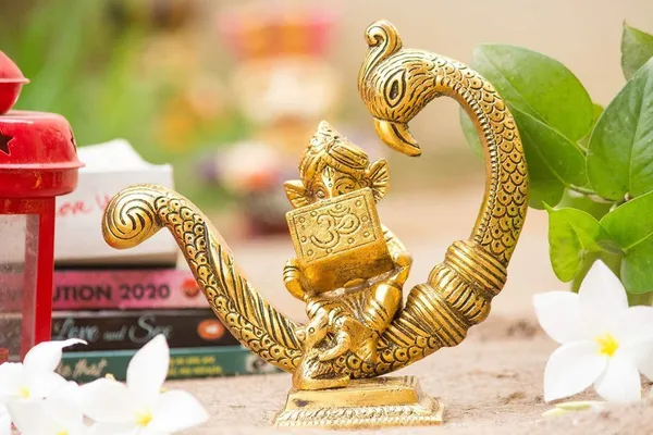 Reading_Ganesha_Idol_on_Peacock_Brass_Finish_Ganpati_Statue_with_Book_and_Om_Symbol_for_Home_Decor,_Office_Desk_&_Gift_6_Inch