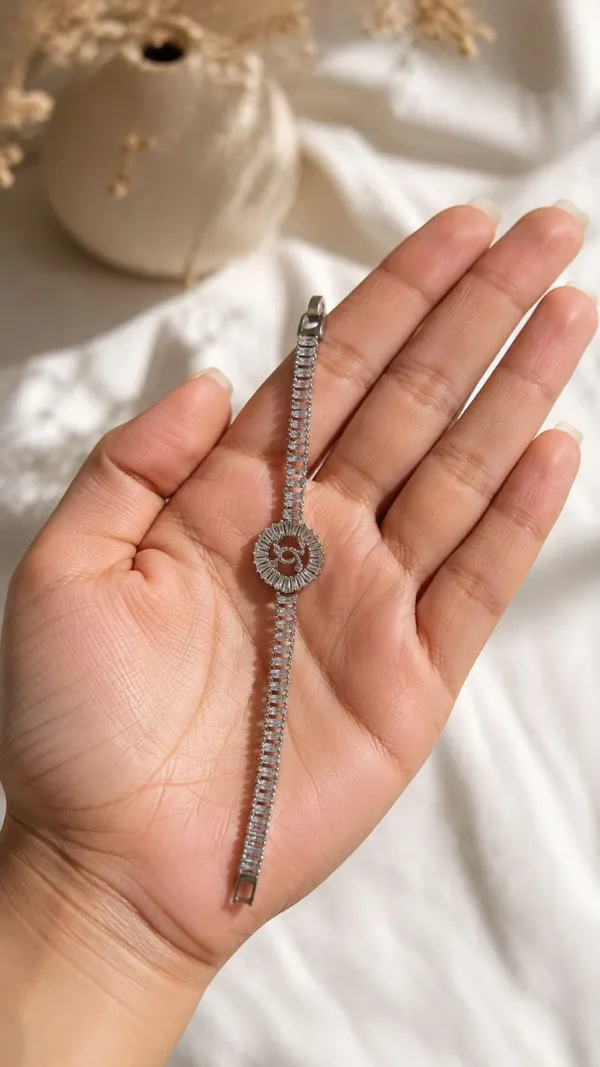 Shubh_aura_presents_A_platinum_plated_bracelet,_its_design_made_with_CC_monogram_topped_with_a_small_diamond_stone,_Its_crafted_with_2_C_interlock_with_bold_and_iconic_statement_,_Its_Sparkle_and_polished_finish_add_timelss_beauty