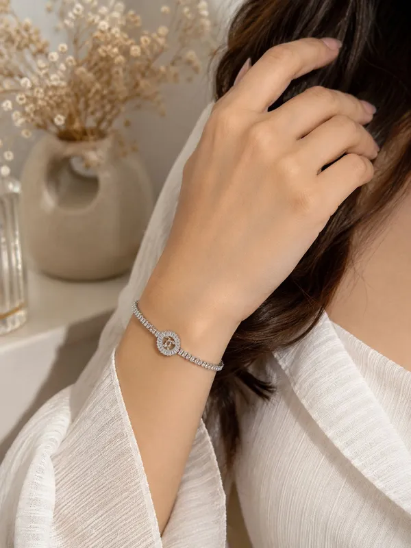 Shubh_aura_presents_A_platinum_plated_bracelet,_its_design_made_with_CC_monogram_topped_with_a_small_diamond_stone,_Its_crafted_with_2_C_interlock_with_bold_and_iconic_statement_,_Its_Sparkle_and_polished_finish_add_timelss_beauty