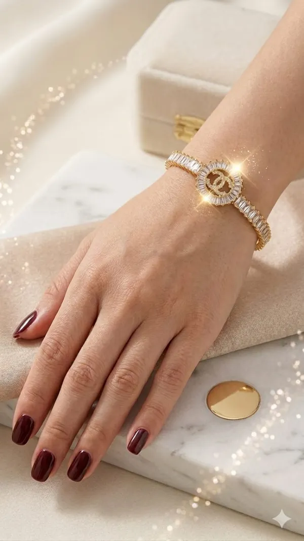 Shubh_aura_presents_A_gold_plated_bracelet,_its_design_made_with_CC_monogram_topped_with_a_small_diamond_stone,_Its_crafted_with_2_C_interlock_with_bold_and_iconic_statement_,_Its_Sparkle_and_polished_finish_add_timelss_beauty