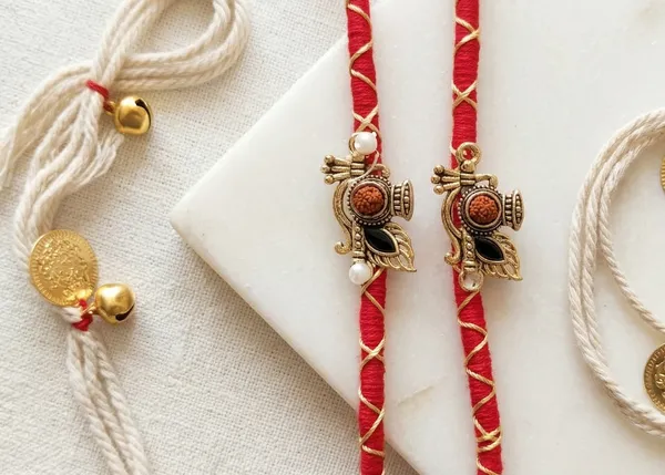 Krishna_Feather_&_Bansuri_Rakhi_Pair_with_Rudraksha_Beads_–_Premium_Spiritual_Rakhi_Set