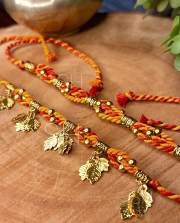 Handmade_Bhaiya_Bhabhi_Couple_Rakhi_Set,_Traditional_Moli_Thread_Rakhi,_Festive_Lumba_Set_with_Golden_Leaf_Charms_and_Antique_Beads