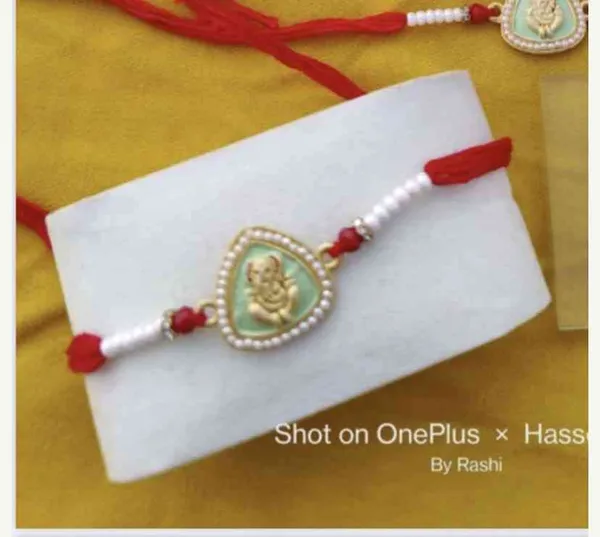 Enamel_rakhi_with_ganesha_on_the_centre_with_pearl_studded_sides