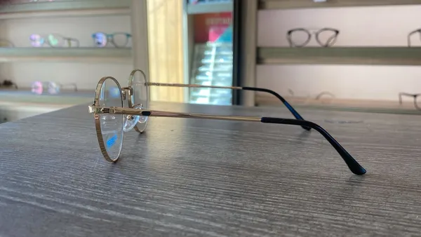 Gold_And_Black_Titanium_Oval_Rim_Metal_Optical_Frame_For_Women_With_Bule_Cut_Glasses