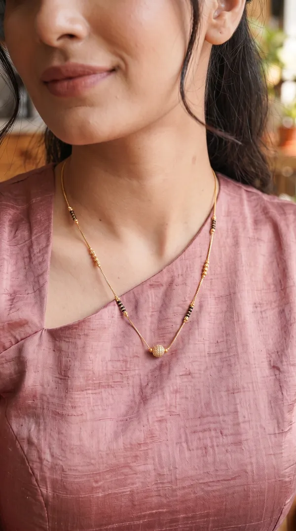 Add_a_graceful_traditional_touch_to_your_jewellery_collection_with_this_elegant_black-beaded_mangalsutra._Featuring_gold-toned_bead_detailing_and_a_beautifully_curved_crystal-studded_pendant,_it_offers_a_sophisticated_blend_of_traditional_charm_and_modern_elegance._Perfect_for_daily_wear,_festive_occasions,_family_functions,_and_special_gatherings._Pairs_beautifully_with_sarees,_kurtis,_ethnic_dresses,_and_other_traditional_outfits.