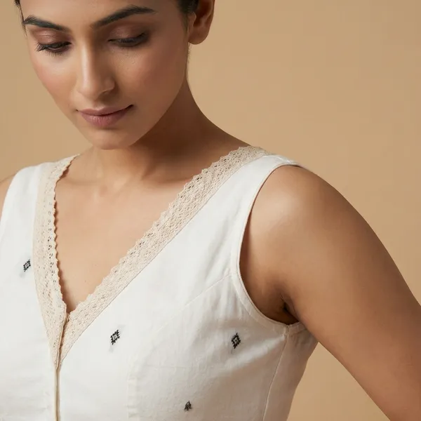 White_Embellished_Sleeveless_Blouse_With_Pearl_Trim_And_Mirror_Work