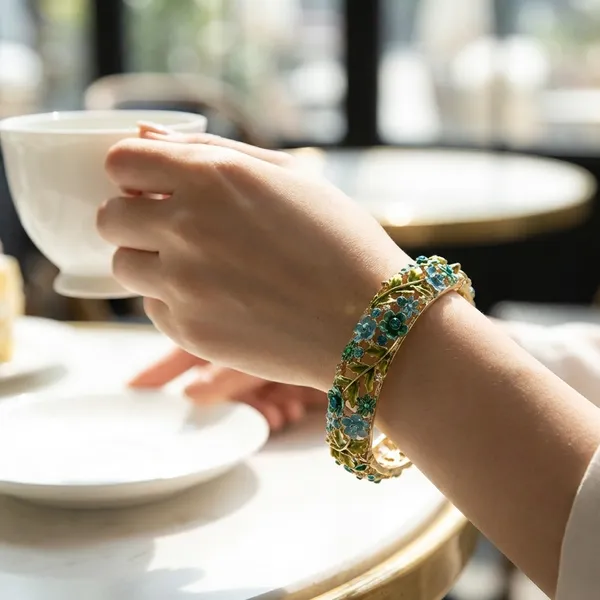 Elegant_Gold_Tone_Floral_Bangle_With_Blue_And_Green_Gemstone_Accents_For_Women