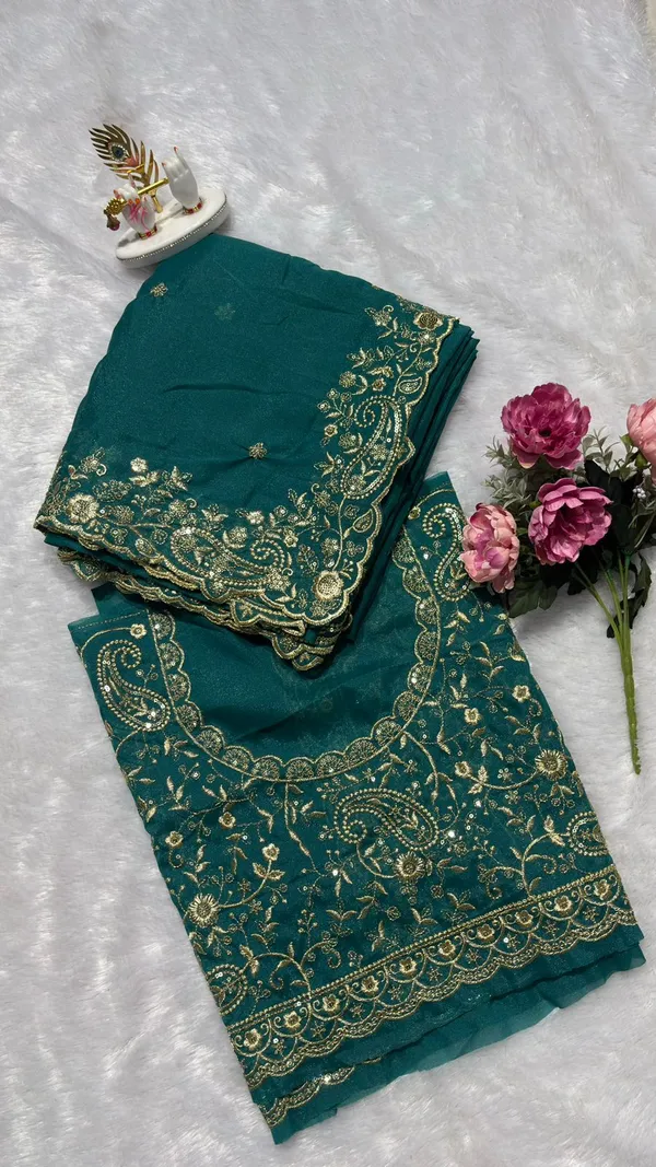 Stunning_Teal_Green_Designer_Saree_Step_into_the_spotlight_with_this_sophisticated_teal_green_saree._It_features_a_rich,_heavy_zari_embroidery_border_with_a_beautiful_scalloped_edge_and_delicate_paisley_motifs._The_saree_is_adorned_with_elegant_buttis_throughout_and_comes_with_a_matching,_heavily_embroidered_designer_blouse_piece_to_complete_your_festive_look