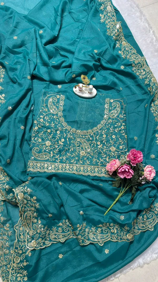 Stunning_Teal_Green_Designer_Saree_Step_into_the_spotlight_with_this_sophisticated_teal_green_saree._It_features_a_rich,_heavy_zari_embroidery_border_with_a_beautiful_scalloped_edge_and_delicate_paisley_motifs._The_saree_is_adorned_with_elegant_buttis_throughout_and_comes_with_a_matching,_heavily_embroidered_designer_blouse_piece_to_complete_your_festive_look