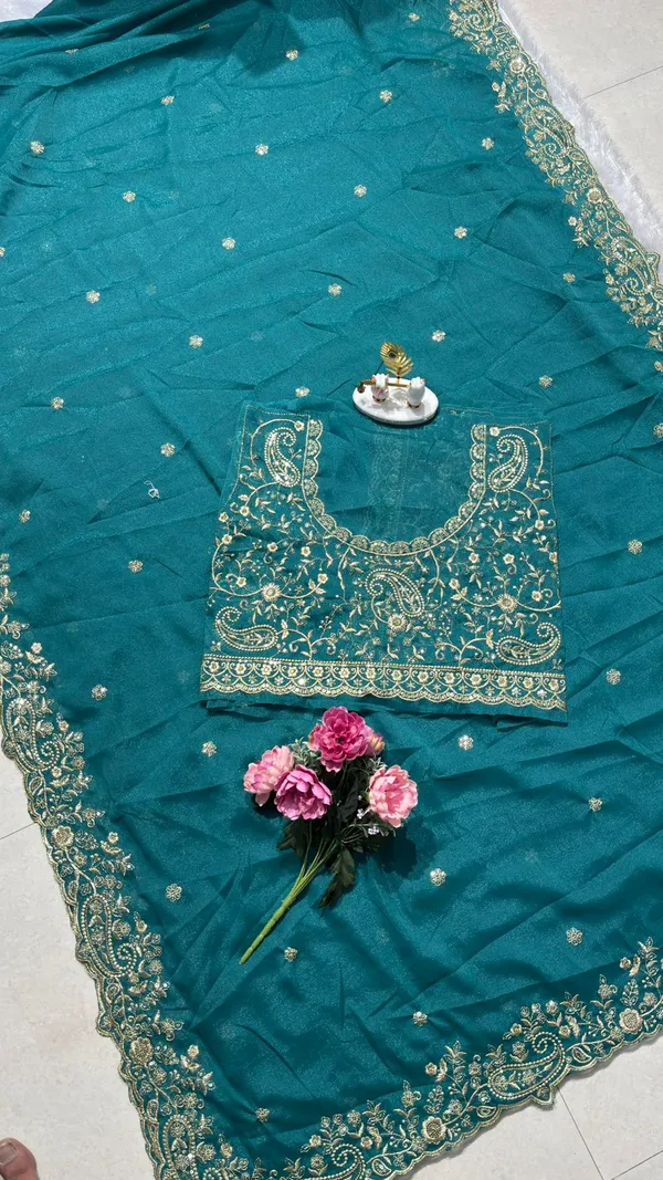 Stunning_Teal_Green_Designer_Saree_Step_into_the_spotlight_with_this_sophisticated_teal_green_saree._It_features_a_rich,_heavy_zari_embroidery_border_with_a_beautiful_scalloped_edge_and_delicate_paisley_motifs._The_saree_is_adorned_with_elegant_buttis_throughout_and_comes_with_a_matching,_heavily_embroidered_designer_blouse_piece_to_complete_your_festive_look