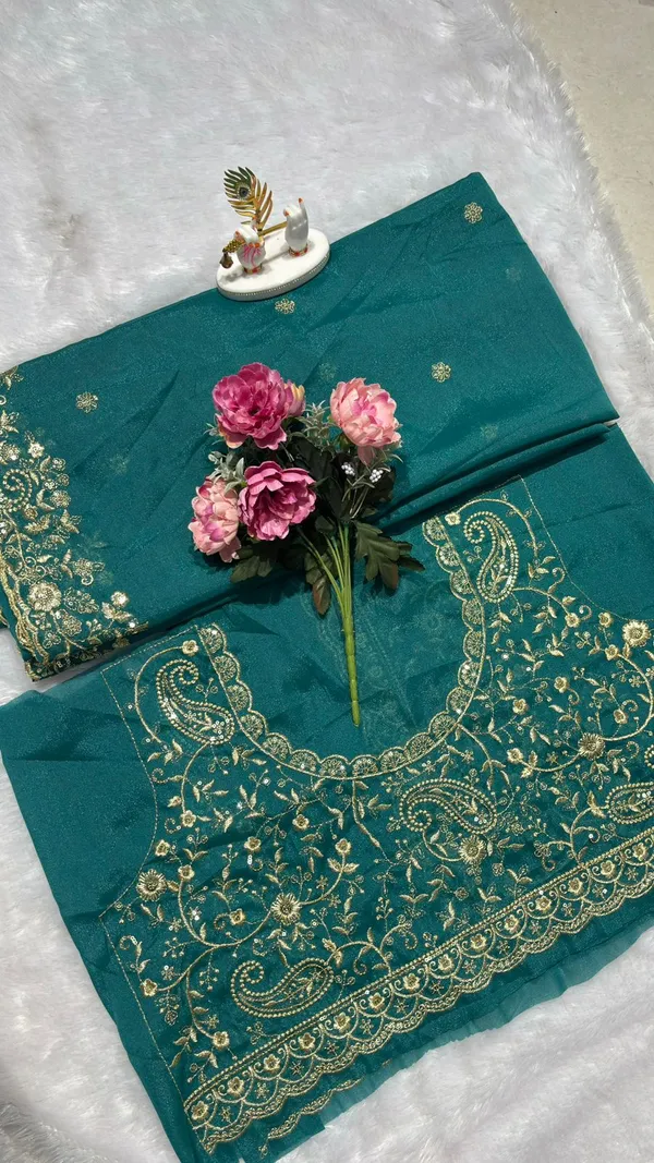 Stunning_Teal_Green_Designer_Saree_Step_into_the_spotlight_with_this_sophisticated_teal_green_saree._It_features_a_rich,_heavy_zari_embroidery_border_with_a_beautiful_scalloped_edge_and_delicate_paisley_motifs._The_saree_is_adorned_with_elegant_buttis_throughout_and_comes_with_a_matching,_heavily_embroidered_designer_blouse_piece_to_complete_your_festive_look