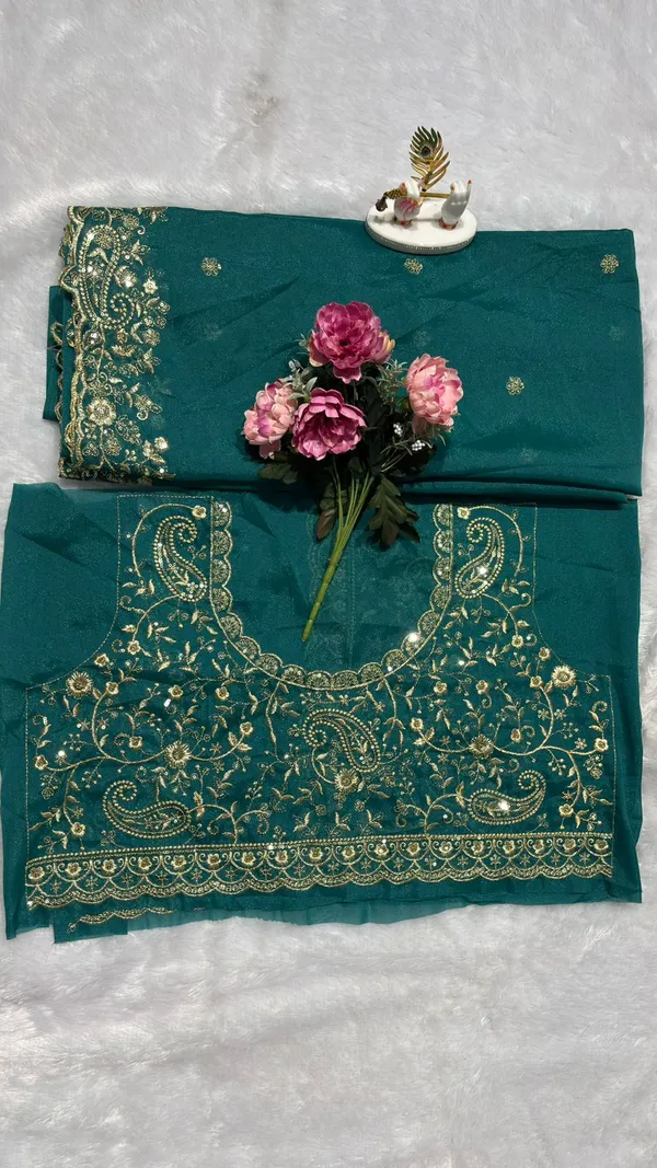 Stunning_Teal_Green_Designer_Saree_Step_into_the_spotlight_with_this_sophisticated_teal_green_saree._It_features_a_rich,_heavy_zari_embroidery_border_with_a_beautiful_scalloped_edge_and_delicate_paisley_motifs._The_saree_is_adorned_with_elegant_buttis_throughout_and_comes_with_a_matching,_heavily_embroidered_designer_blouse_piece_to_complete_your_festive_look